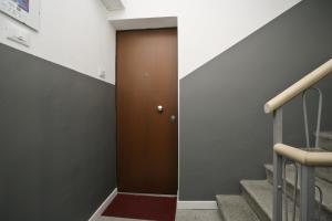 un couloir avec une porte marron et des escaliers dans l'établissement Venice Residence Elisabeth, à Mestre