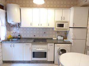 a kitchen with white cabinets and a sink and a dishwasher at Casa Anita in Luarca