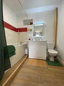 uma casa de banho com um WC, um lavatório e uma banheira em La maison des rosiers au bord du Loir 
