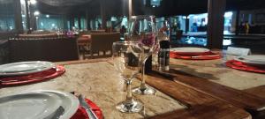 una mesa de madera con dos copas de vino. en Gravatá - Flat Fazenda Monte Castelo en Sairé