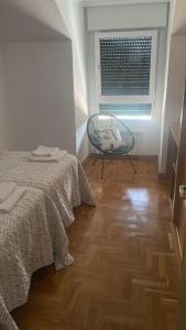 a bedroom with a bed and a chair and a window at Valdellera VI in Posada de Llanes