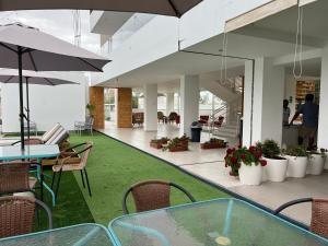 a patio with a glass table and chairs and plants at Hotel Balistra in Ica