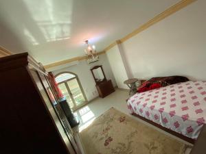 een kleine slaapkamer met een bed en een raam bij شقة مفروشة بالمهندسين محيط نادي الصيد موقع متميز 3غرف نوم مكيفة بالكامل in Caïro