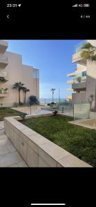 a view of a park with palm trees and a building at Superbe appartement à mohammadia in Mohammedia