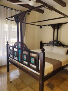 1 dormitorio con cama con dosel en una habitación en Mangos Villas - Lucia en Kilifi