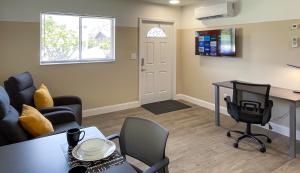 a living room with a table and chairs and a desk at Lazy Cuckoo Inn - Sleek and Stylish Studio Apartments in Fort Myers Beach