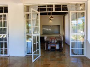 a dining room with a table and glass doors at Mangos Villas - Lucia in Kilifi
