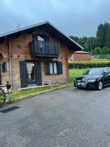 a car parked in front of a house with a balcony at Chalet des 2 lacs in Xonrupt-Longemer