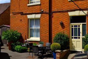 a brick house with a table and chairs in front of it at The Queen Hotel in Olney