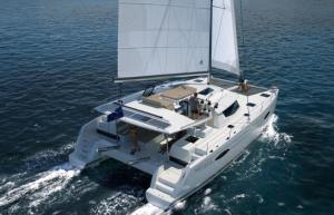 a white boat with a sail in the water at Placencia Sailing Catamaran Day Charter « Gingembre » in Placencia Village