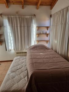 une chambre avec un grand lit et une fenêtre dans l'établissement Calisto casa, por los caminos del vino, Mendoza, à Luján de Cuyo