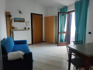 - un salon avec un canapé bleu et une table dans l'établissement I Quattro Laghi Casa delle Stelle, à Brebbia