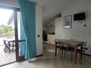 - une cuisine et une salle à manger avec une table et des chaises dans l'établissement I Quattro Laghi Casa delle Stelle, à Brebbia