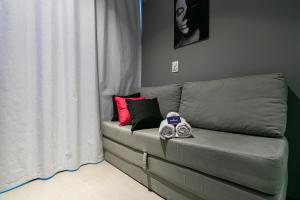 un divano grigio in un soggiorno accanto a una finestra di Novo e Brilhante Studio em Higienópolis-Academia a San Paolo