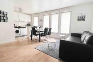 a living room with a couch and a table with chairs at Appart Pleyel familiale, St Denis, Paris, CGD in Saint-Denis