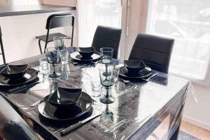 a table with plates and glasses on top at Appart Pleyel familiale, St Denis, Paris, CGD in Saint-Denis