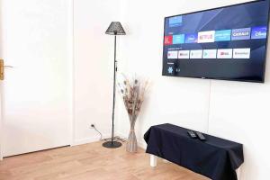a room with a table and a television and a vase of flowers at Appart Pleyel familiale, St Denis, Paris, CGD in Saint-Denis +10 photos