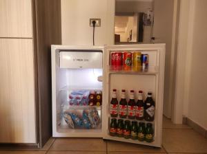 an open refrigerator filled with drinks and soda at Sa Teria Village - Camere Deluxe - in Tertenìa