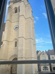 una torre alta con un reloj en un edificio en « Au cœur de Dole », en Dole