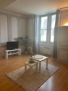a living room with a table on a rug at « Au cœur de Dole » in Dole