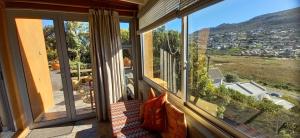 een kamer met een bank en een groot raam bij Glencairn Vista in Kaapstad
