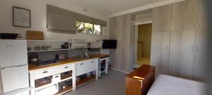 een keuken met witte kasten en een bank in een kamer bij Glencairn Vista in Kaapstad +21 foto's