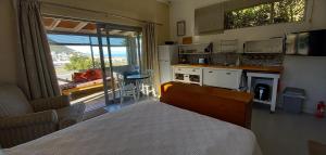 een slaapkamer met een bed en een keuken met uitzicht bij Glencairn Vista in Kaapstad