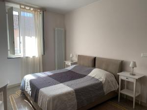 - une chambre avec un lit, deux tables et une fenêtre dans l'établissement Case Rossa e Blu, à Villanova dʼAlbenga