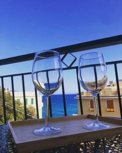 2 bicchieri da vino seduti su un tavolo sul balcone di Il Sogno di Contardi A Affittacamere a Monterosso al Mare