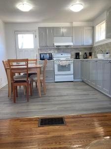 cocina con armarios blancos, mesa y sillas en Luckin Retreat with Large Backyard, en Trenton