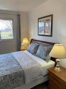 ein Schlafzimmer mit einem Bett, zwei Lampen und einem Fenster in der Unterkunft Luckin Retreat with Large Backyard in Trenton