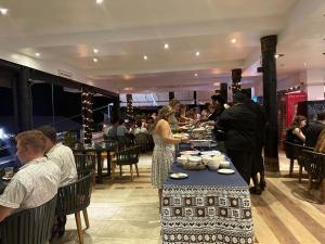 grupa ludzi stojących przy stole z jedzeniem w obiekcie The Crow's Nest Resort Fiji w mieście Korotogo