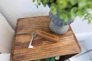 een sleutel op een houten tafel naast een vaas bij The Blackwater Suite in Colchester