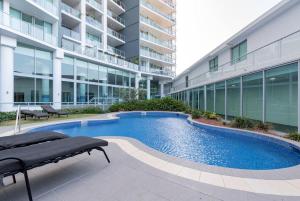 a swimming pool in front of a building at Southport Sea Views - Shores Apartment in Gold Coast