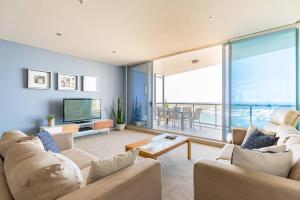 a living room with two couches and a television at Southport Sea Views - Shores Apartment in Gold Coast