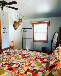 a bedroom with a bed with a deer head on the wall at 3 Bedroom log cabin with hot tub at Bear Mountain in Eureka Springs