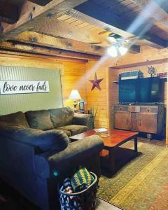 a living room with a couch and a table at 3 Bedroom log cabin with hot tub at Bear Mountain in Eureka Springs