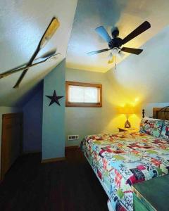 a bedroom with a ceiling fan and a bed at 3 Bedroom log cabin with hot tub at Bear Mountain in Eureka Springs