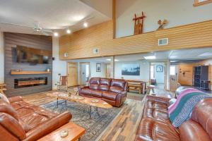 a living room with leather couches and a fireplace at Spacious Old Forge Condo w/ Patio & Fire Pit! in Old Forge