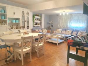 a kitchen and living room with a table and a couch at Amplio Apartamento Playa Puerto de Sagunto in Puerto de Sagunto