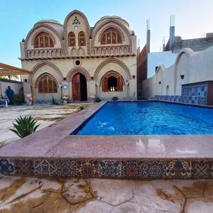 a large swimming pool in front of a building at Mystical habou domes villa in Luxor