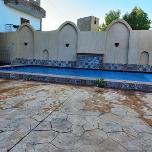 een zwembad in een gebouw met een tegelmuur bij Mystical habou domes villa in Luxor