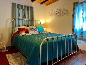 a bedroom with a metal bed with a green comforter at Lookout Cabin in Prescott