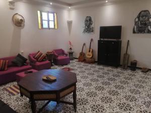 エッサウィラにあるMaison d'hôteのリビングルーム(紫色のソファ、テレビ付)