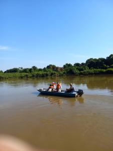 Barco Casa Pantanal Toca da Onça في بوكونيه: مجموعة من الناس في قارب على نهر