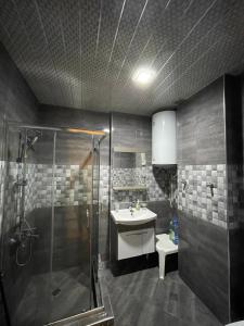 a bathroom with a shower and a sink at Orbi Plaza Black Sea in Batumi