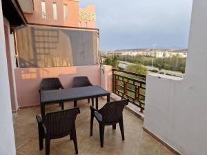 a balcony with a table and chairs on a balcony at Appartement Saidia avec piscine in Saïdia +3 photos