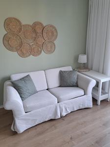 a white couch in a living room with a table at Twoja Przystań in Władysławowo