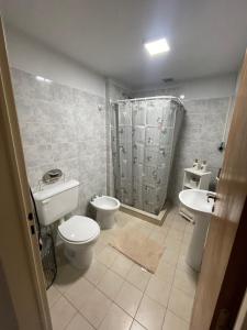 a bathroom with a toilet and a sink and a shower at Maison Rouge Puerto Madryn in Puerto Madryn +13 photos