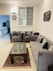a living room with a couch and a coffee table at Bhurban Luxury Apartments in Bhurban